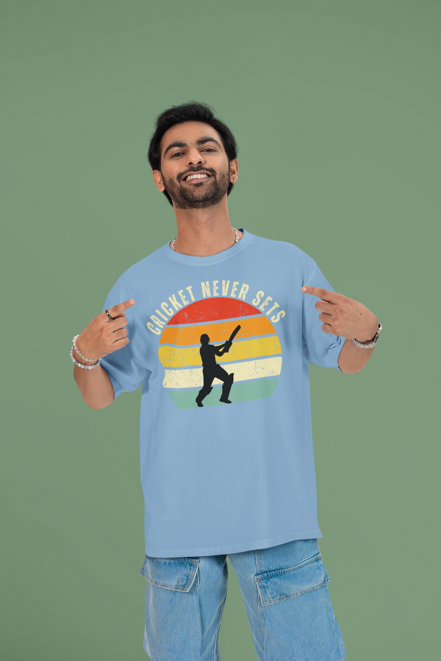 Man wearing a cricket never sets baby blue t-shirt with a colorful graphic and text