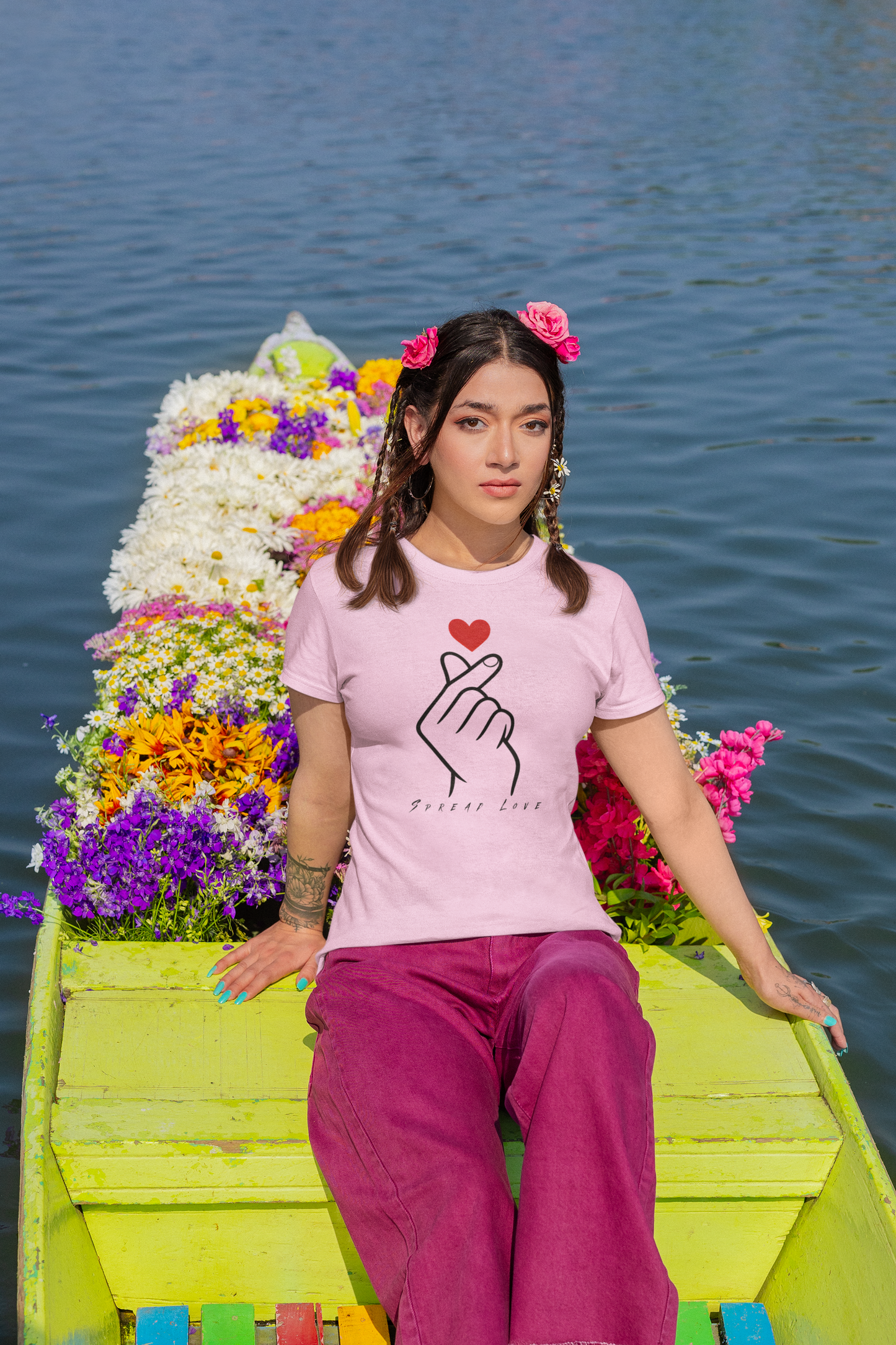 Woman wearing a light pink t-shirt with a design on a boat decorated with flowers