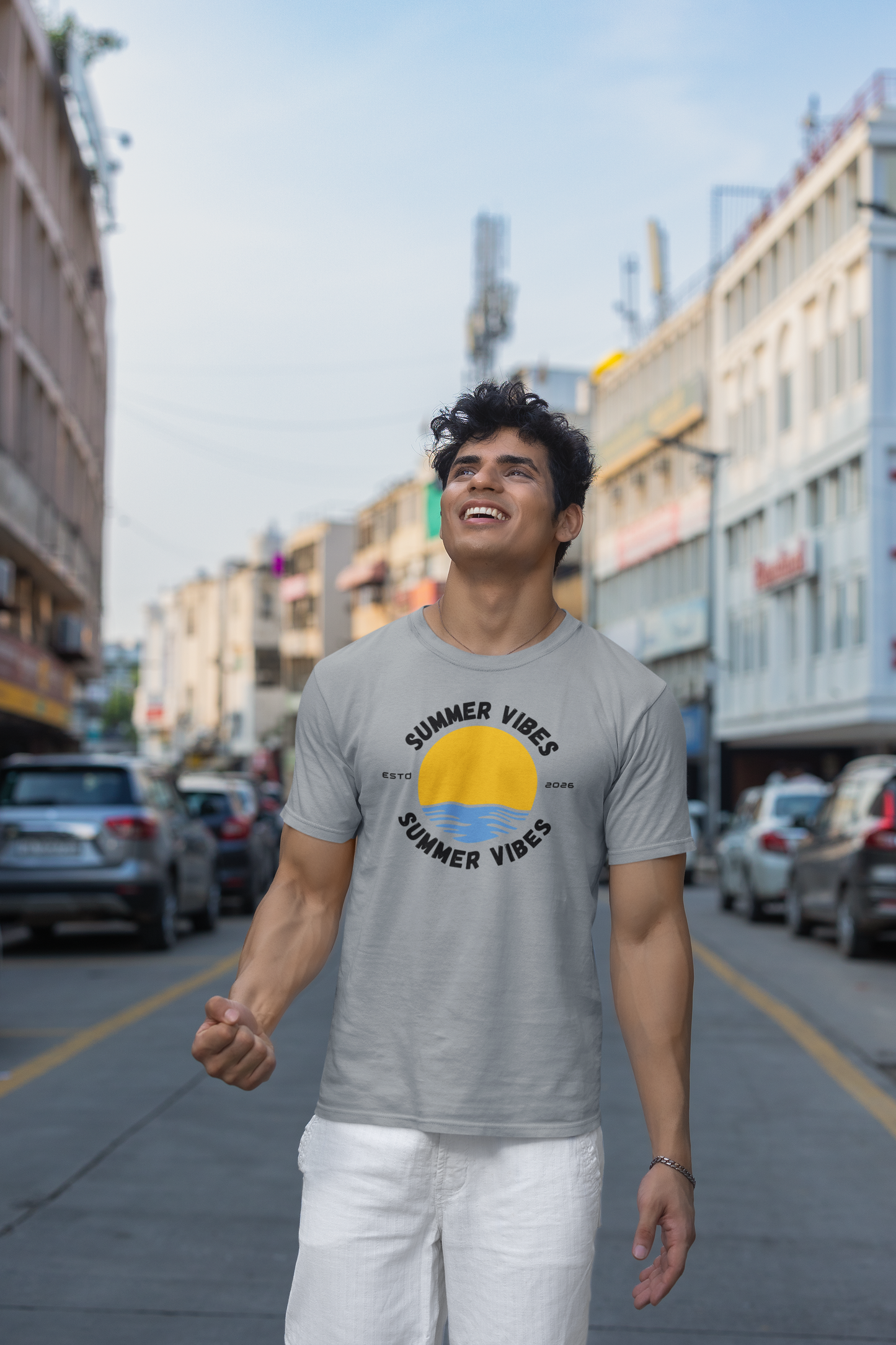 Man wearing a silver frost 'Summer Vibes' t-shirt on a city street
