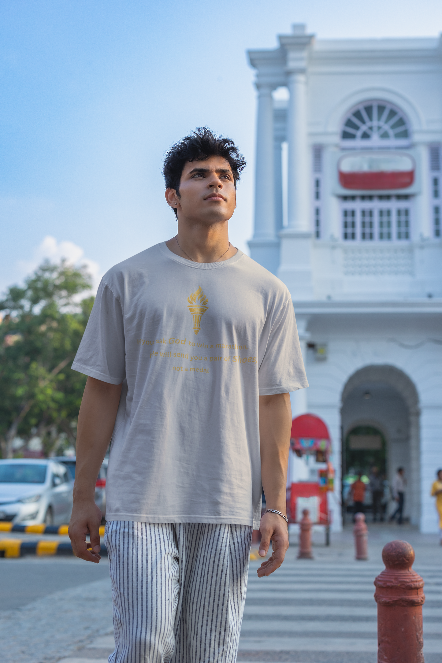 Grey Melange textured oversized t-shirt featuring a distressed golden torch graphic and motivational marathon message.
