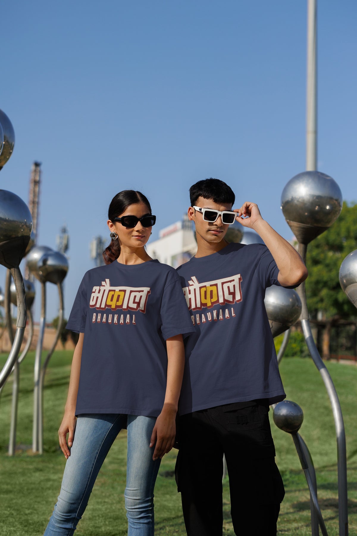 Navy Blue Bhaukaal oversized t-shirt worn by a man and a woman outdoors, Hindi typography print across the chest