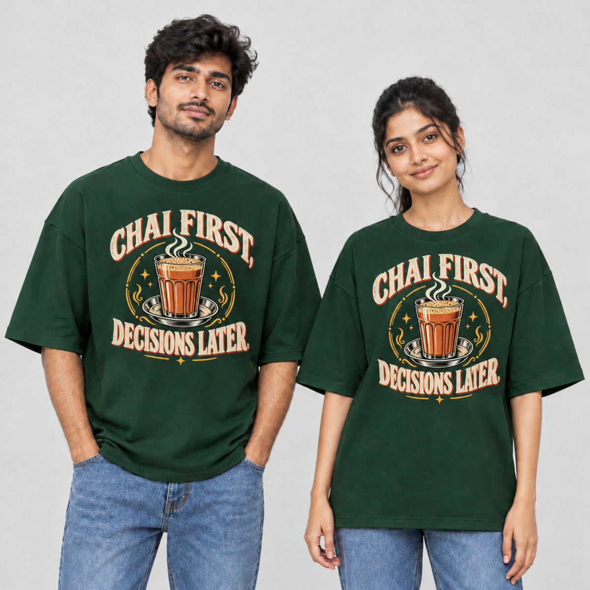 Bottle Green Chai First Decisions Later unisex oversized T-shirt worn by a man and a woman, front print with a cutting chai glass and retro cream lettering