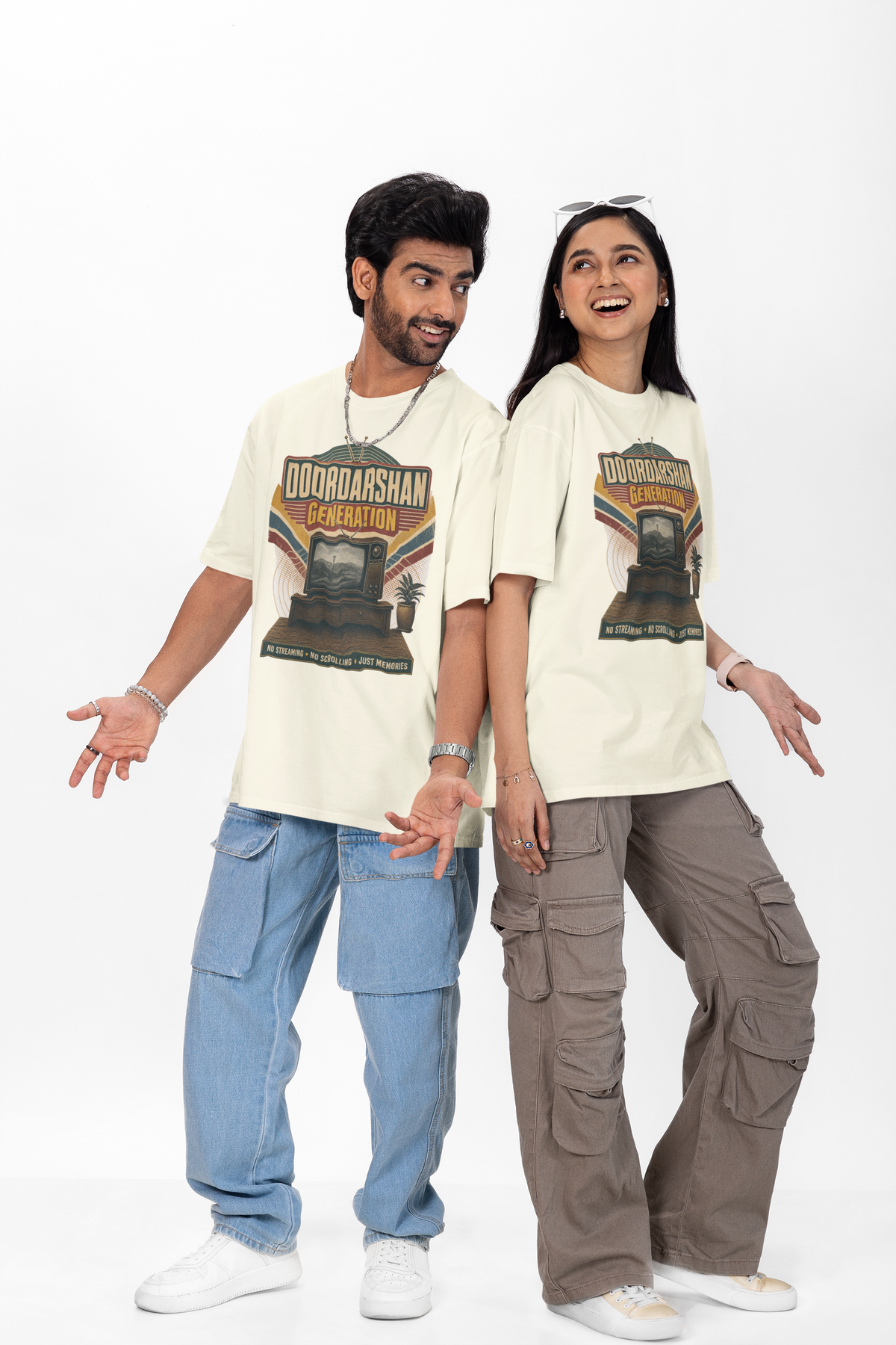 Man and woman wearing the Off white Doordarshan Generation oversized t-shirt with baggy jeans on a plain backdrop