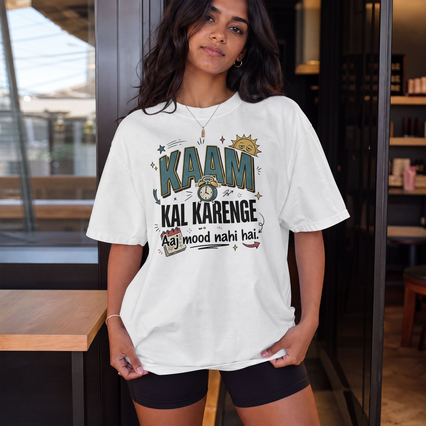 White Nauma oversized t-shirt, model shot, with bold 'Kaam Kal Karenge' typography and doodle-style artwork.