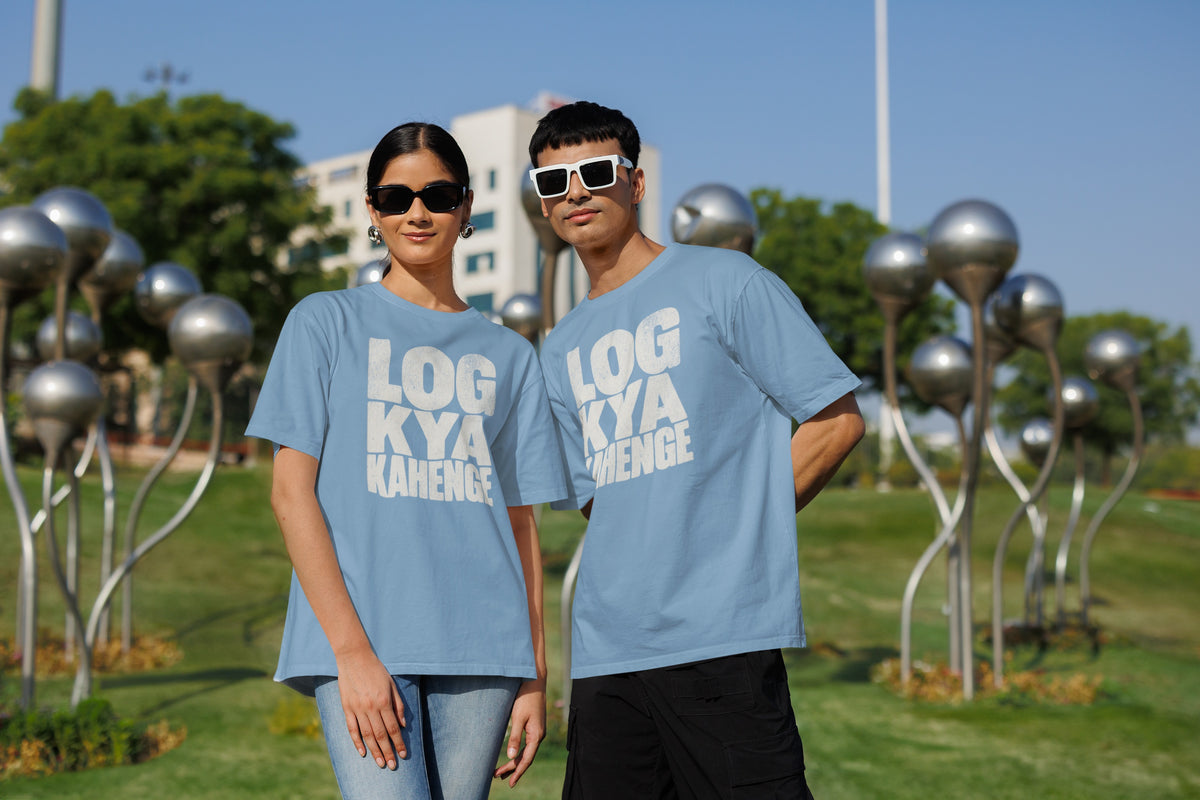 Baby Blue Log Kya Kahenge oversized t-shirt worn by a man and a woman in a park, distressed Hinglish slogan print across the chest
