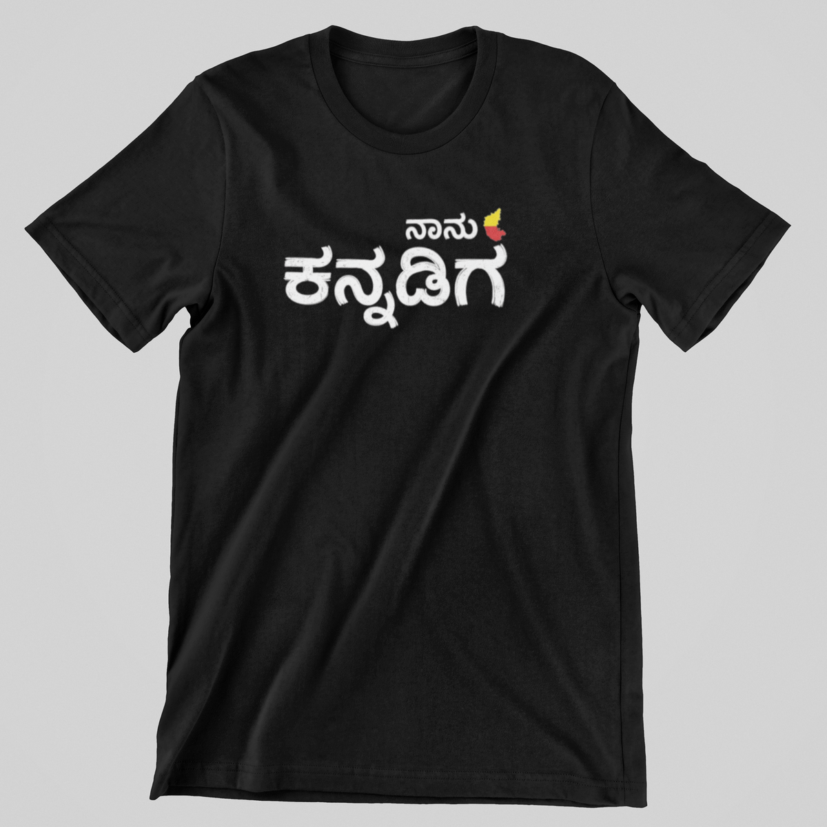 Black Naanu Kannadiga graphic T-shirt flat view showing bold white ಕನ್ನಡಿಗ lettering with a red and yellow accent – Nauma