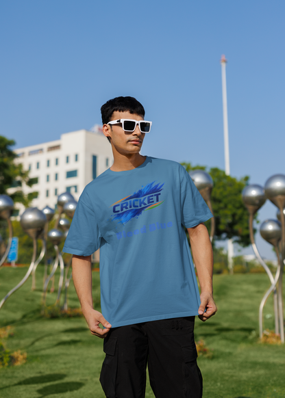 Person wearing a baby blue t-shirt with a colorful graphic design outdoors on a sunny day.