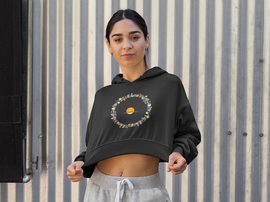 Black Woman wearing a black hoodie with a circular design against a corrugated metal background