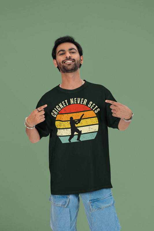 Man wearing a cricket never sets bottle green t-shirt with a colorful graphic and text