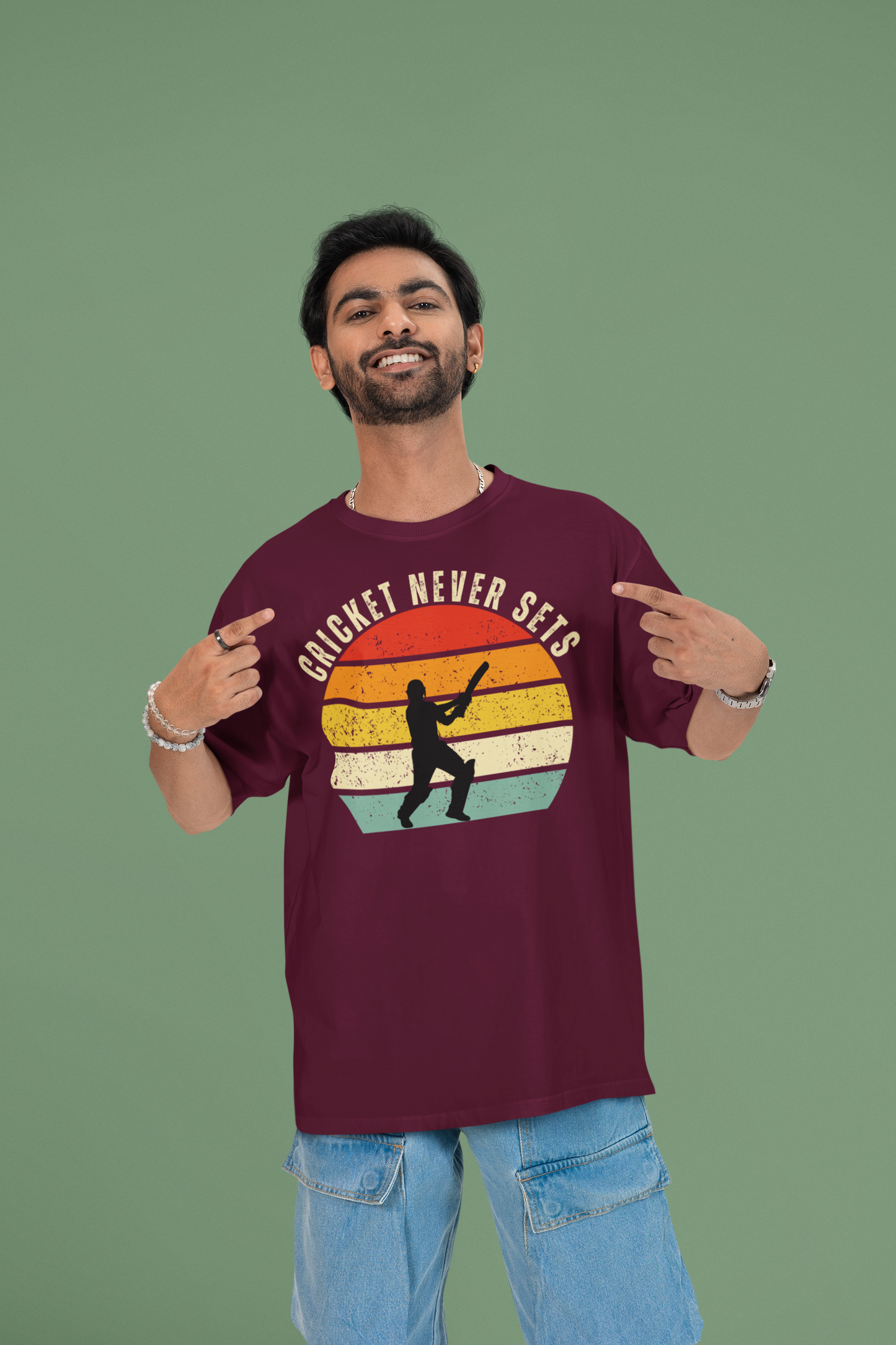 Man wearing a cricket never sets burgundy t-shirt with a colorful graphic and text