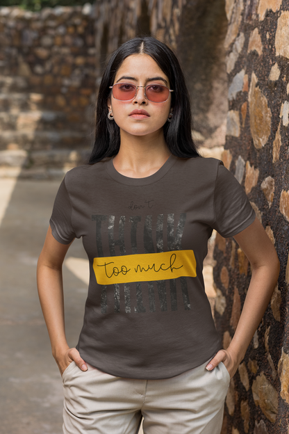 Woman wearing a Charcoal Grey t-shirt with text standing against a stone wall.