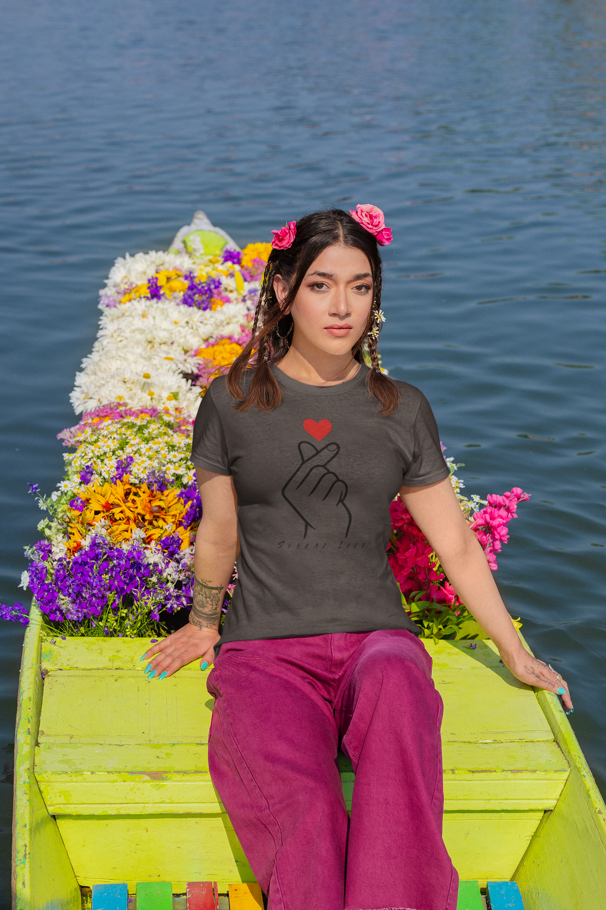 Woman wearing a charcoal grey t-shirt with a design on a boat decorated with flowers
