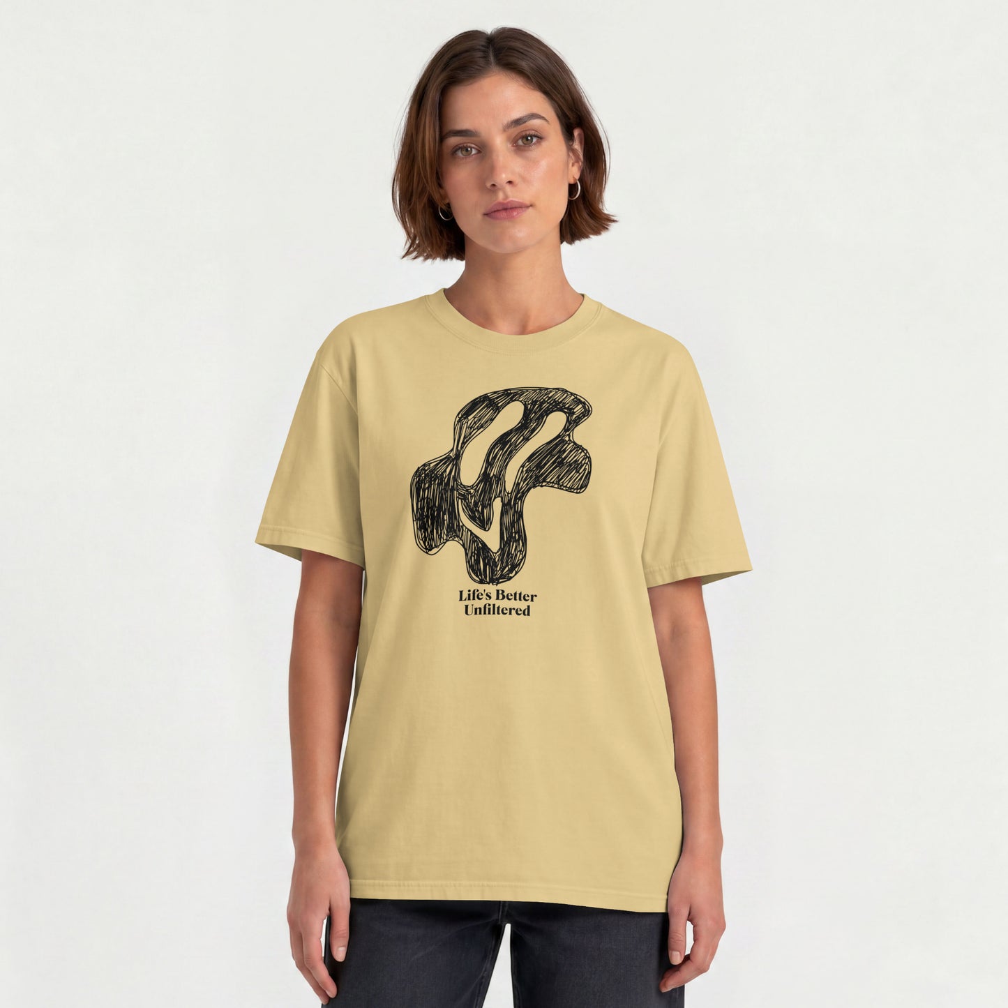 Beige Young woman wearing a relaxed fit cotton tee featuring a melting doodle design and "Life's Better Unfiltered"