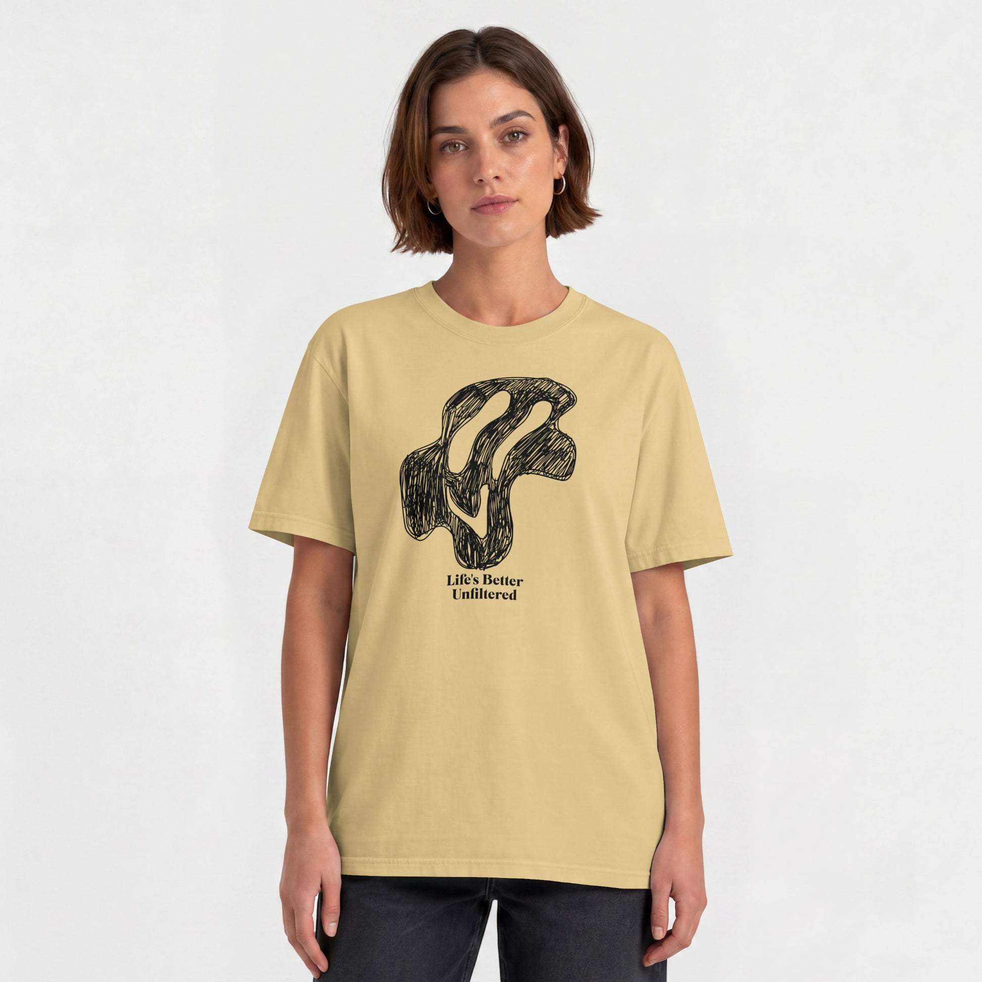 Beige Young woman wearing a relaxed fit cotton tee featuring a melting doodle design and "Life's Better Unfiltered"