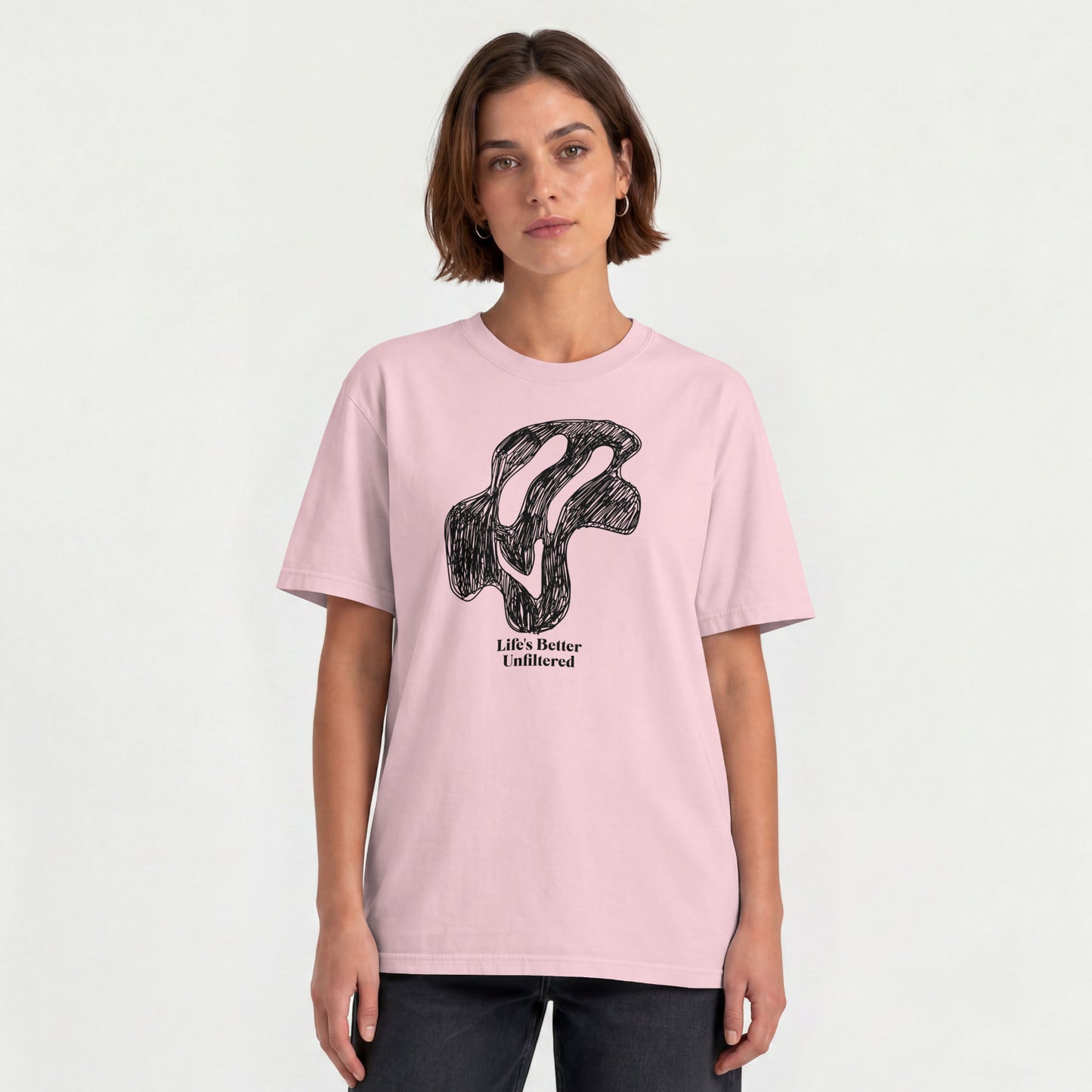 Light Baby Pink Young woman wearing a relaxed fit cotton tee featuring a melting doodle design and "Life's Better Unfiltered"