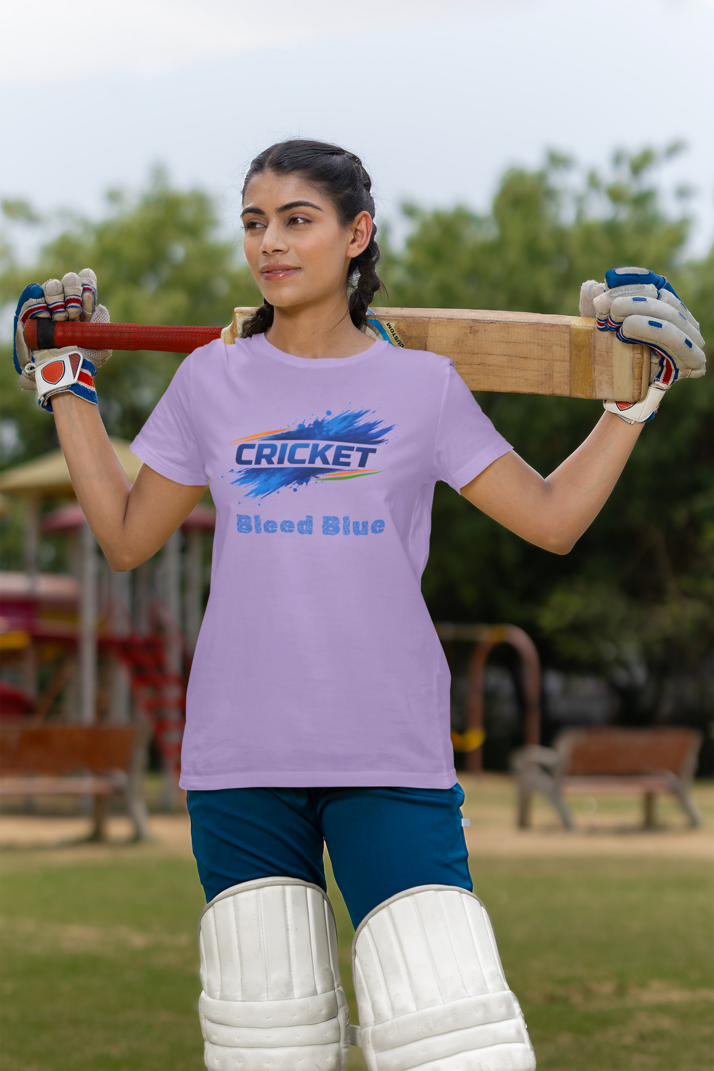 Woman holding a cricket bat with a lavender t-shirt in an outdoor 