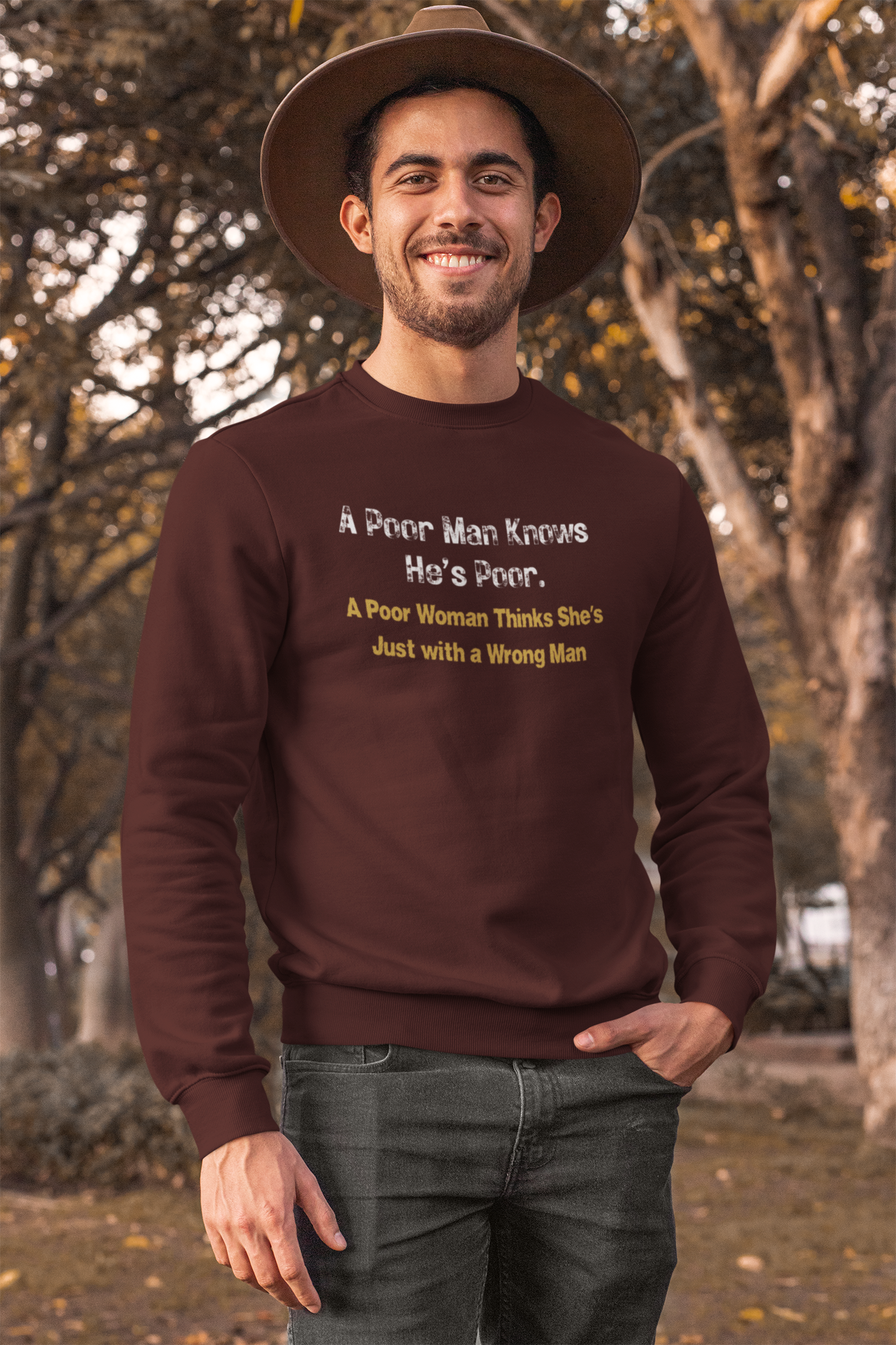 Man wearing a maroon sweatshirt with humorous text in an outdoor setting