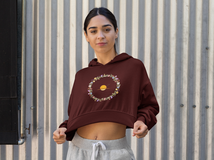 Maroon Woman wearing a maroon hoodie with a circular design against a corrugated metal background