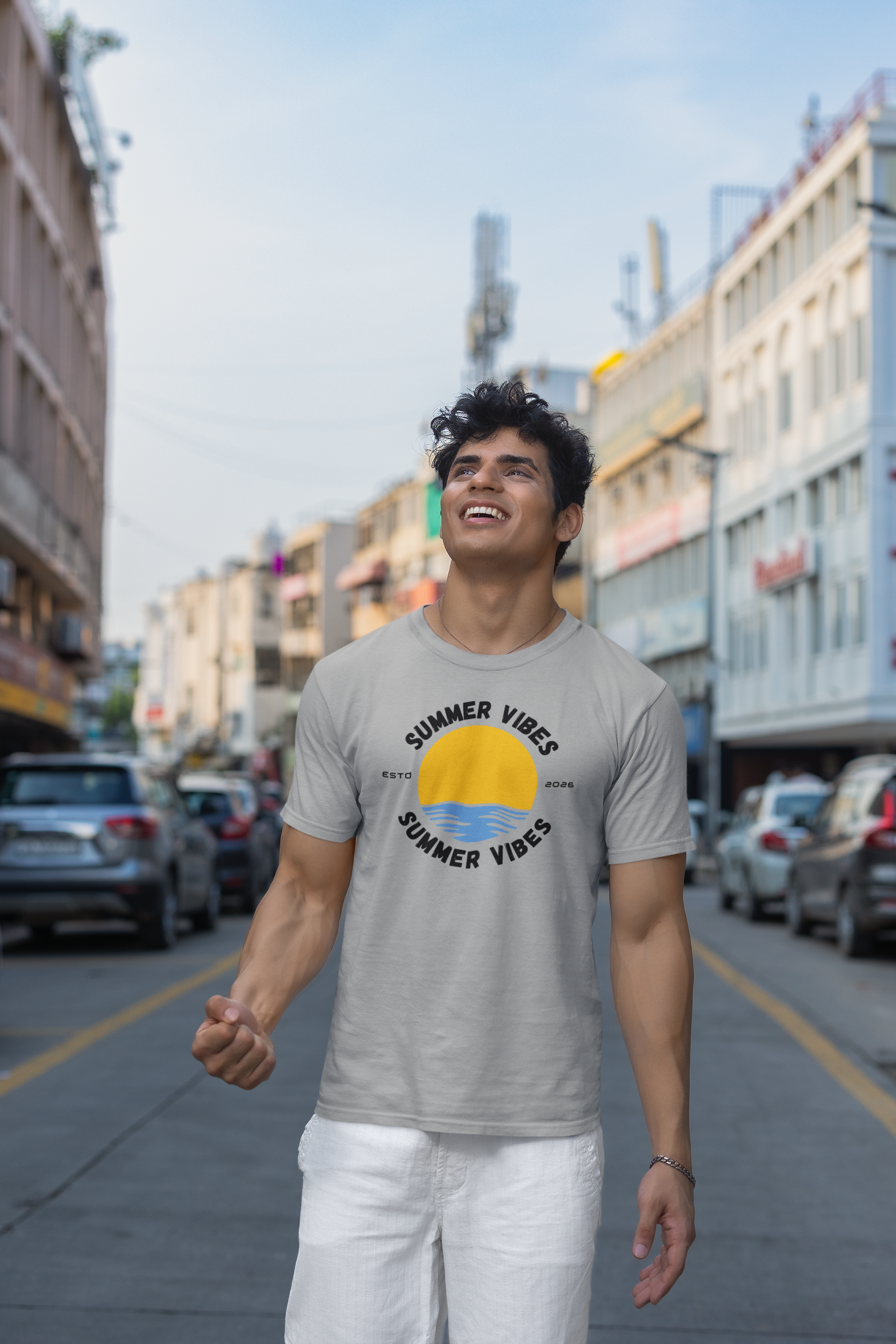 Man wearing a melange grey 'Summer Vibes' t-shirt on a city street