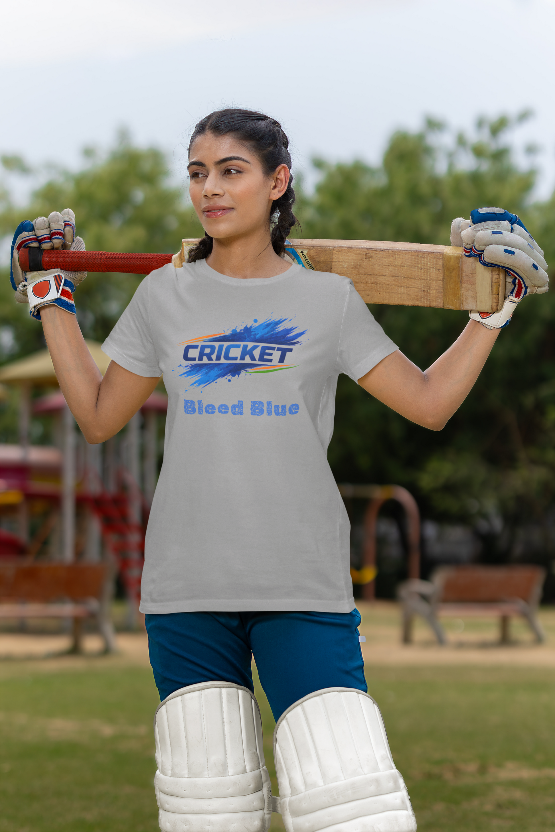 Woman holding a cricket bat with a melange grey t-shirt in an outdoor setting