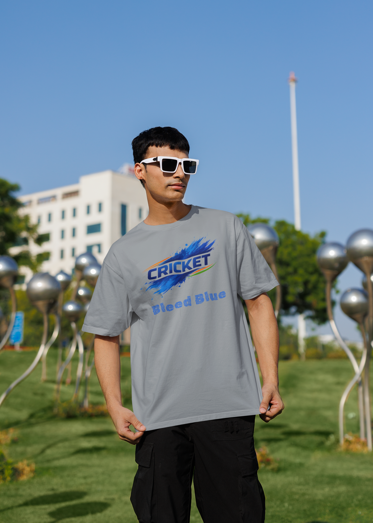 Person wearing a silver frost t-shirt with a colorful graphic design outdoors on a sunny day.