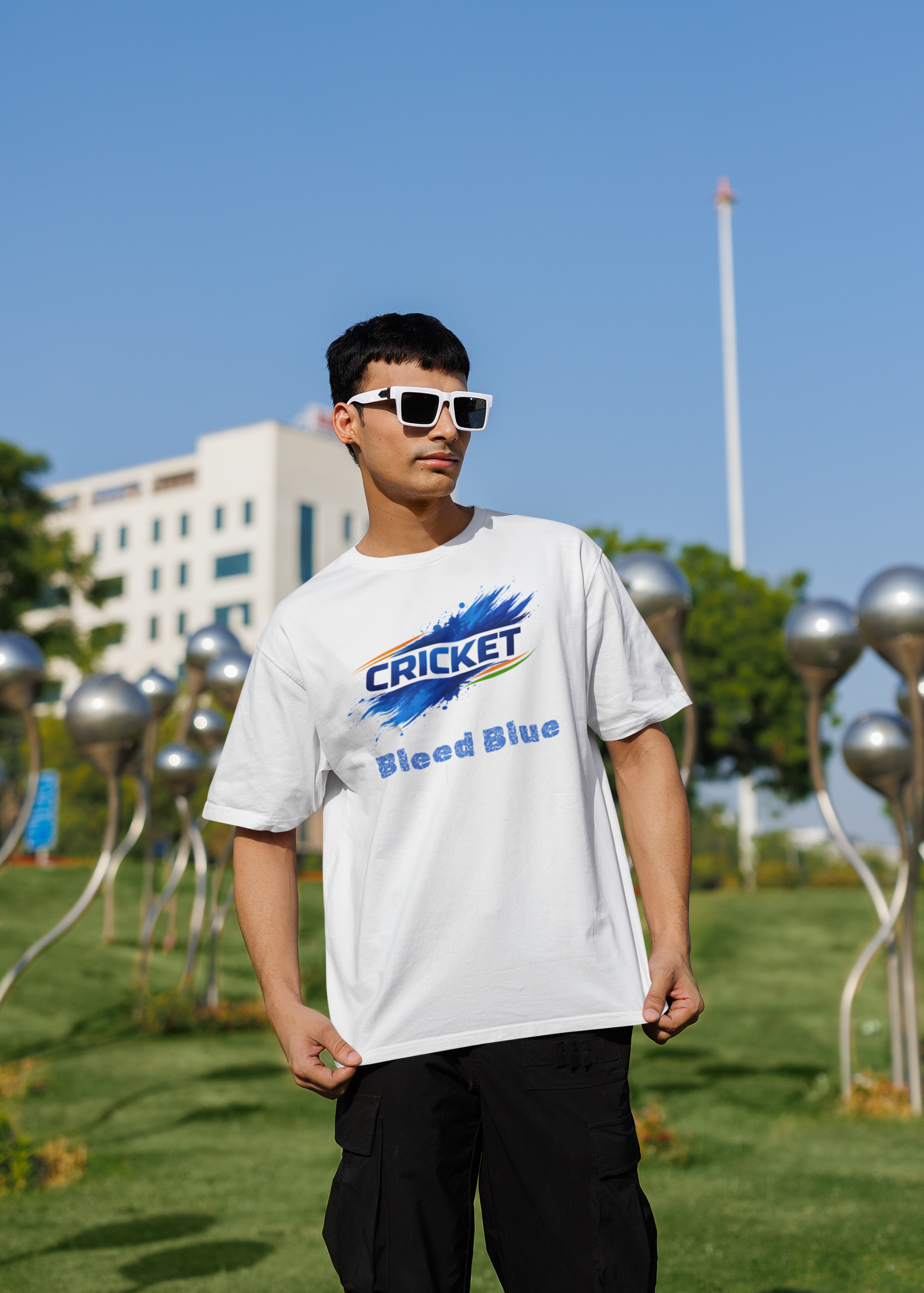 Person wearing a white t-shirt with a colorful graphic design outdoors on a sunny day.