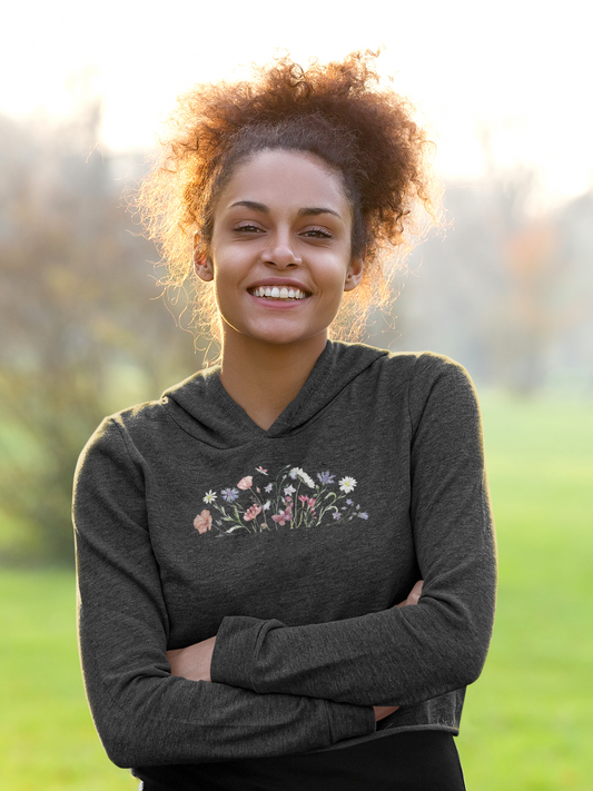 Woman wearing a black hoodie with floral design outdoors