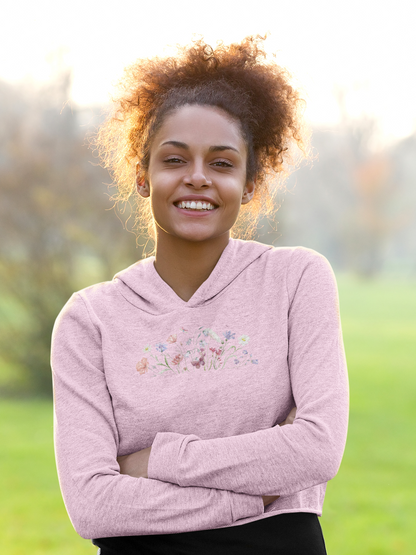 Woman wearing a light pink hoodie with floral design outdoors