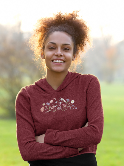 Woman wearing a maroon hoodie with floral design outdoors