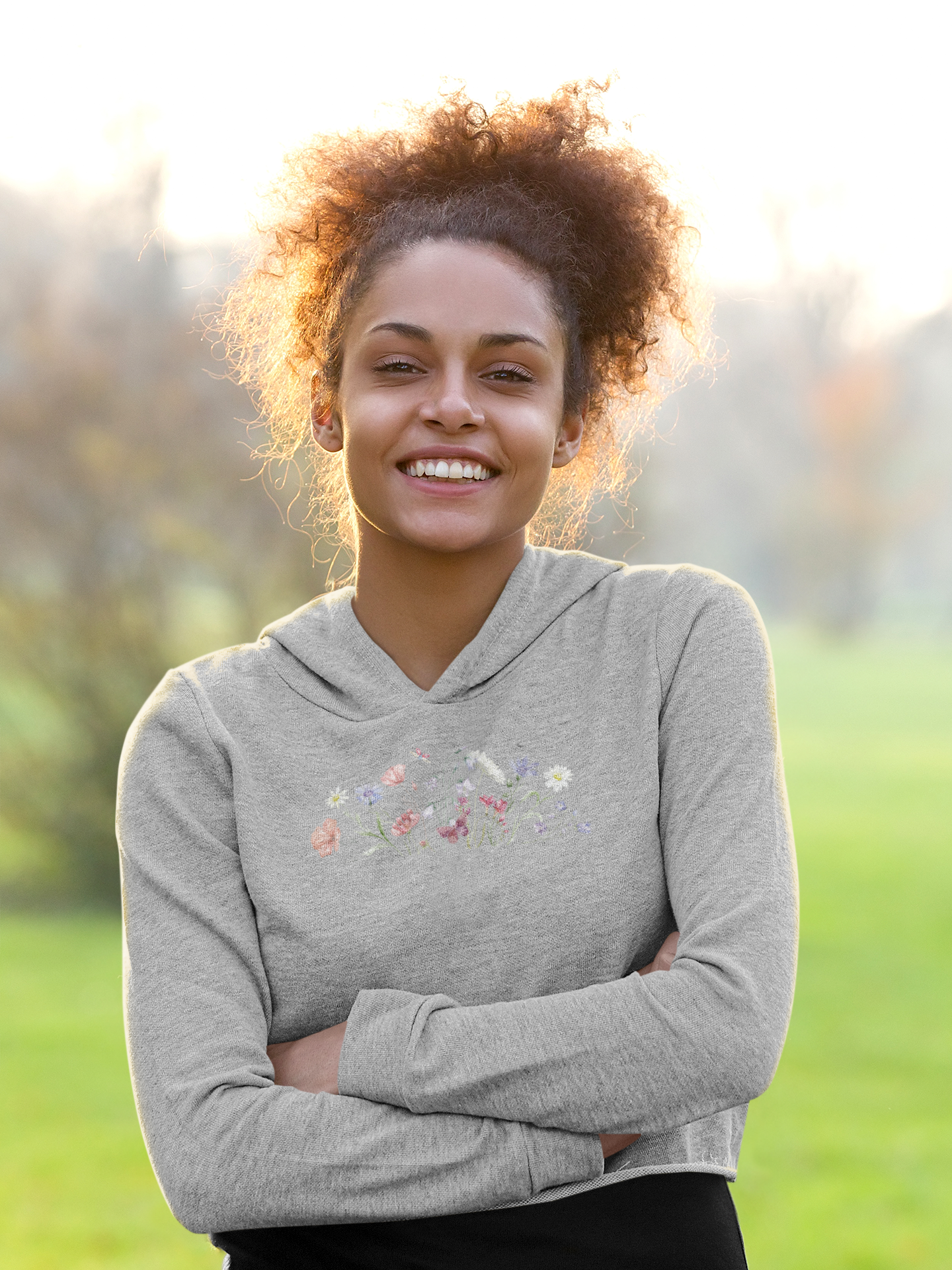 Woman wearing a melange grey hoodie with floral design outdoors