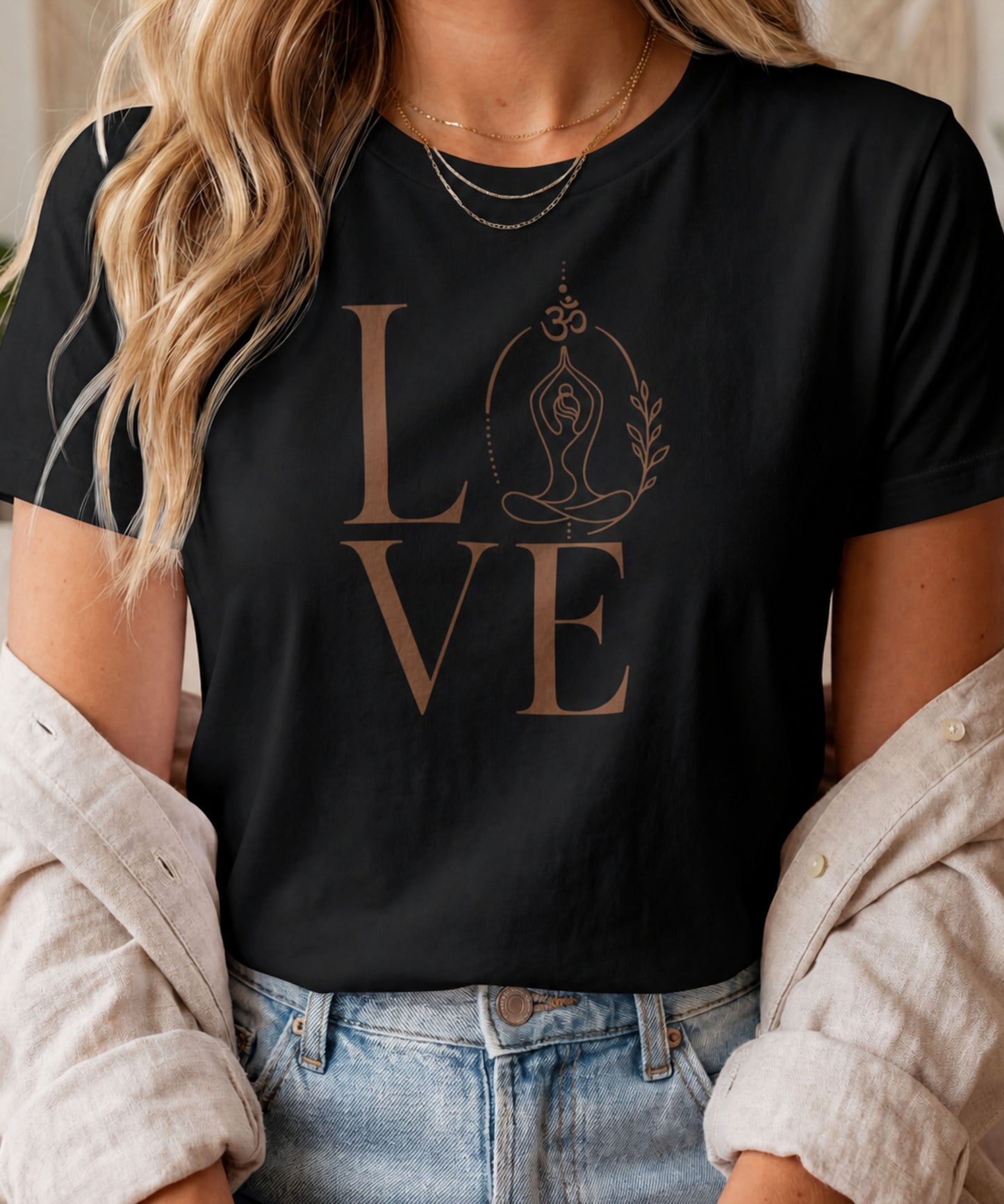 A woman modelling a black graphic t-shirt featuring a minimalist "LOVE" design with a meditating yoga pose and an Om symbol