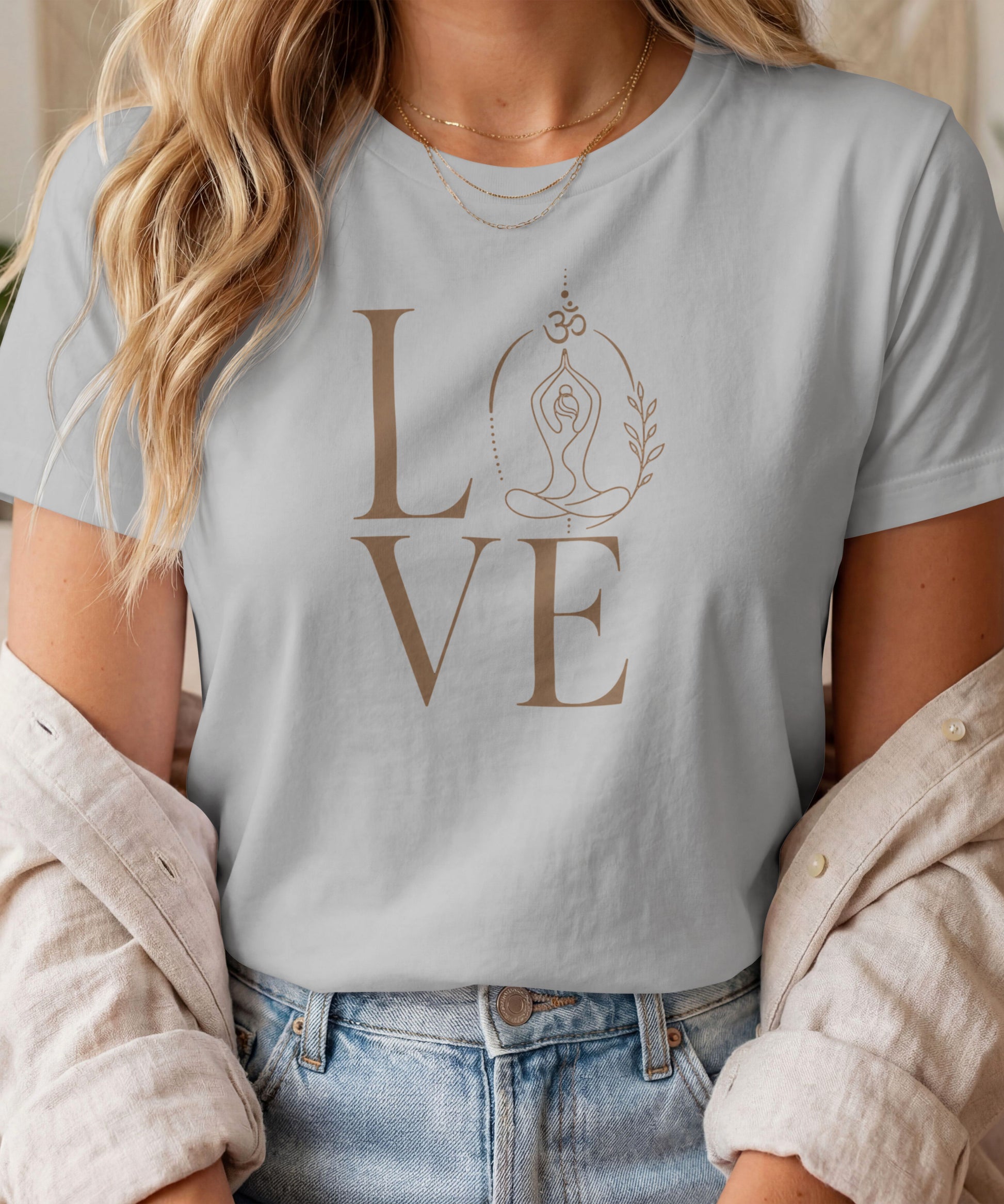 A woman modelling a grey melange graphic t-shirt featuring a minimalist "LOVE" design with a meditating yoga pose and an Om symbol