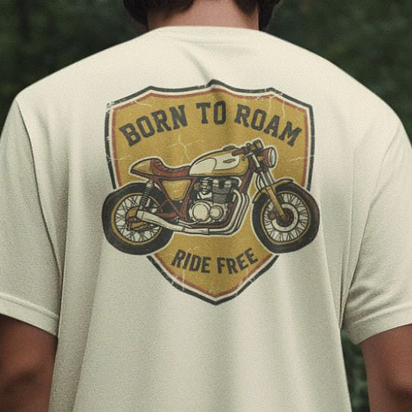 Close-up of the Born To Roam vintage biker badge on an Off White oversized t-shirt, showing the cream-tank cafe racer illustration in detail