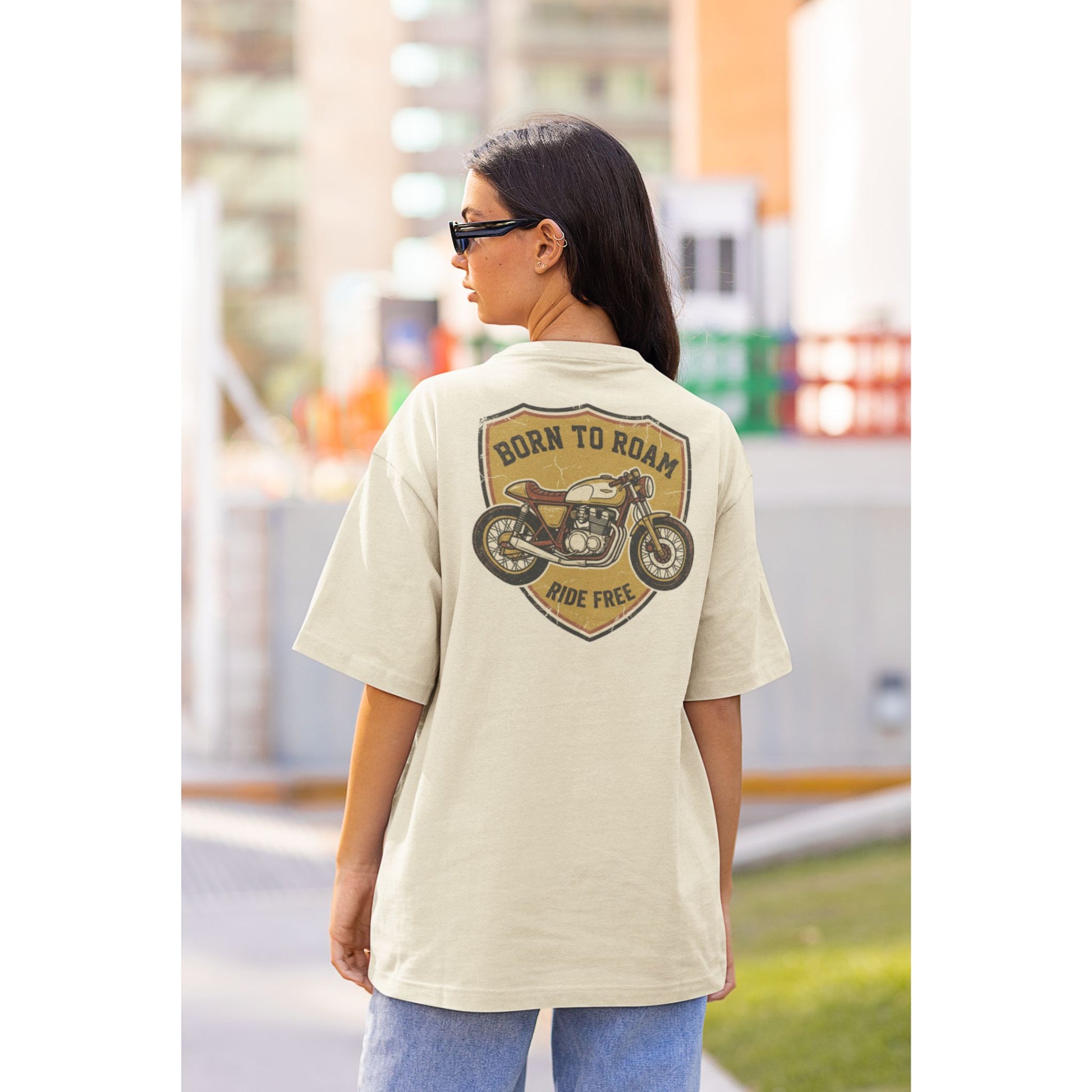 Female model wearing the Nauma Born To Roam cafe racer oversized t-shirt in Off White, boxy unisex fit