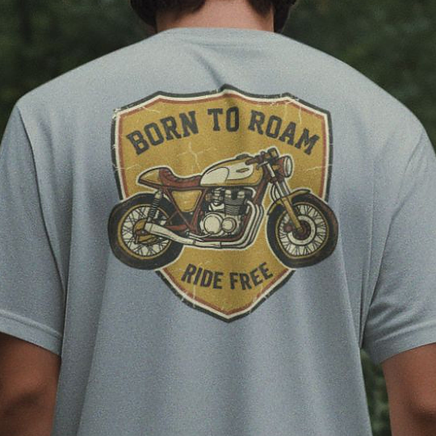 Close-up of the retro motorcycle shield print on a Silver Frost grey oversized t-shirt, showing print detail and scale across the shoulders