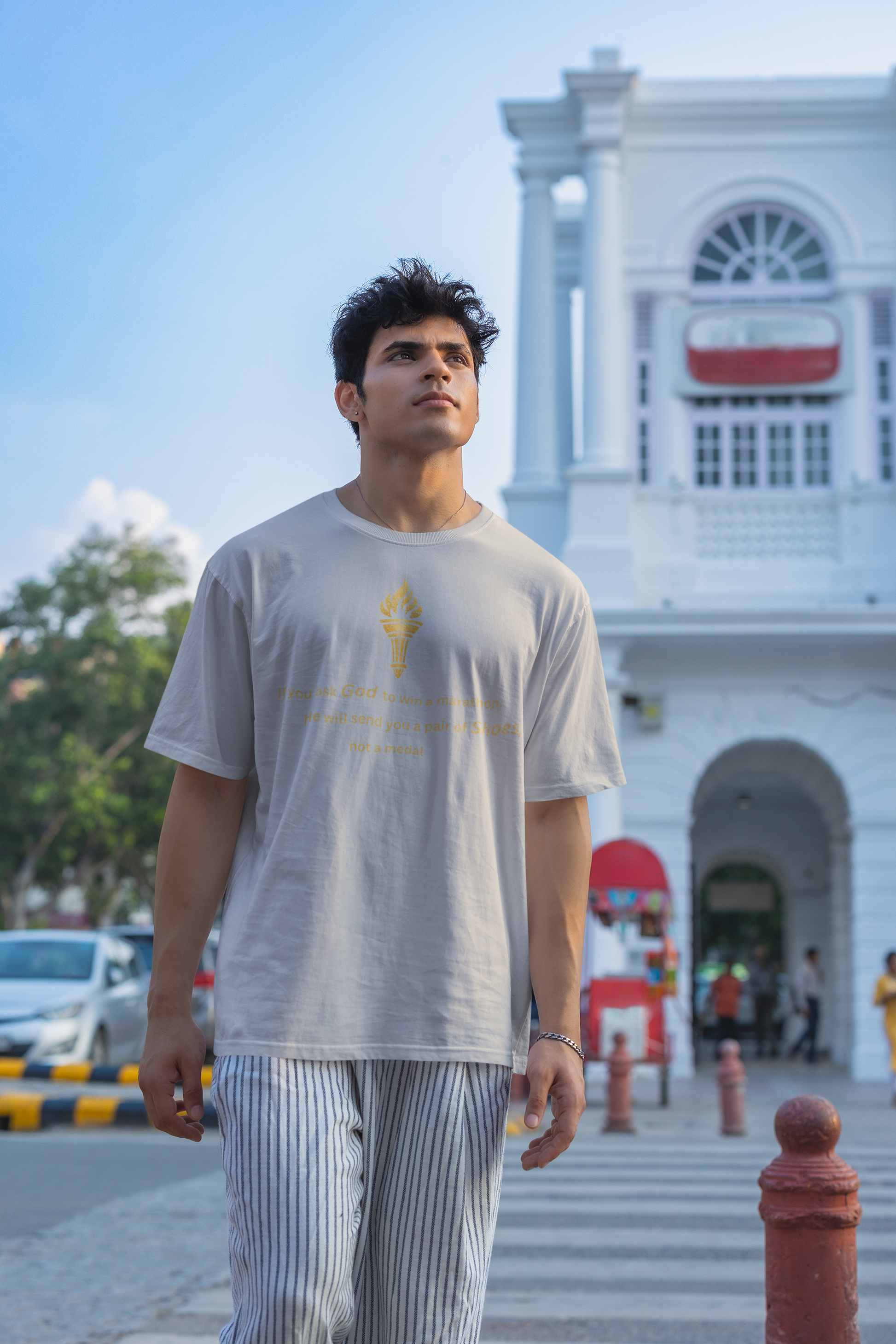 Grey Melange textured oversized t-shirt featuring a distressed golden torch graphic and motivational marathon message.