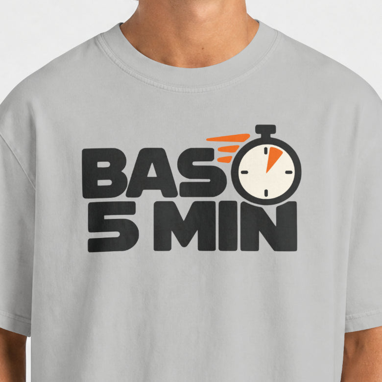 Close-up of the Bas 5 Min print on Melange Grey: chunky black BAS 5 MIN lettering with a stopwatch for the O and orange speed lines