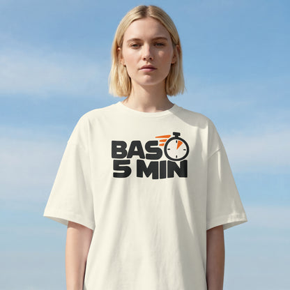 Woman wearing the Off White Bas 5 Min oversized t-shirt against a clear sky, bold BAS 5 MIN lettering on the front