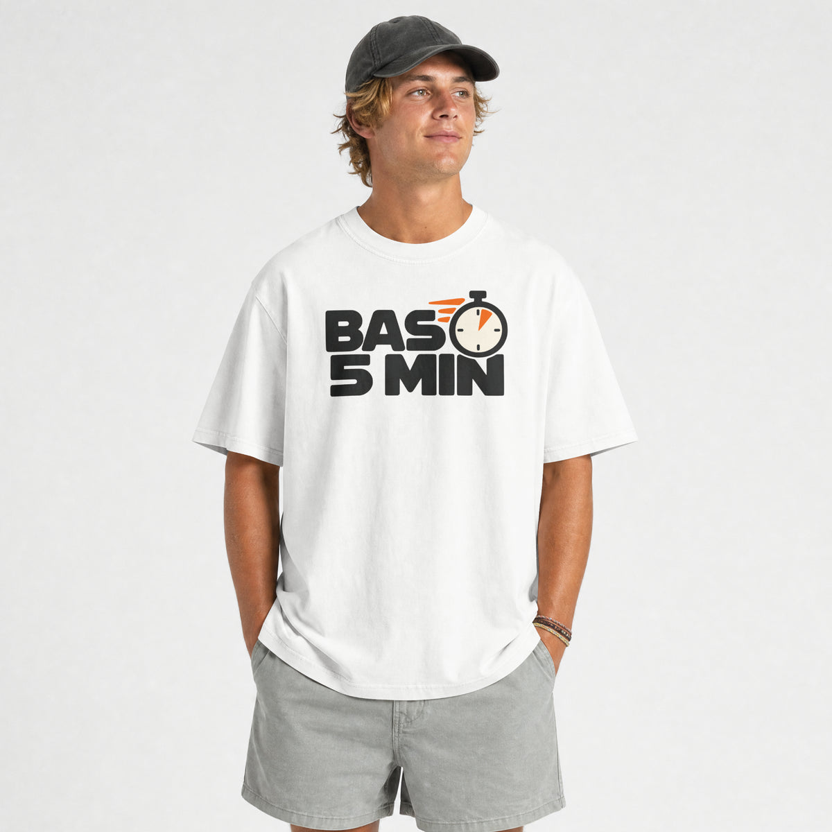 White Bas 5 Min funny Hinglish oversized t-shirt worn by a smiling man with grey shorts, front print visible