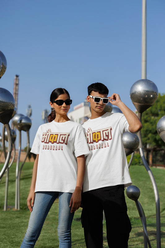 White Bhaukaal oversized t-shirt worn by a man and a woman outdoors, Hindi typography print across the chest