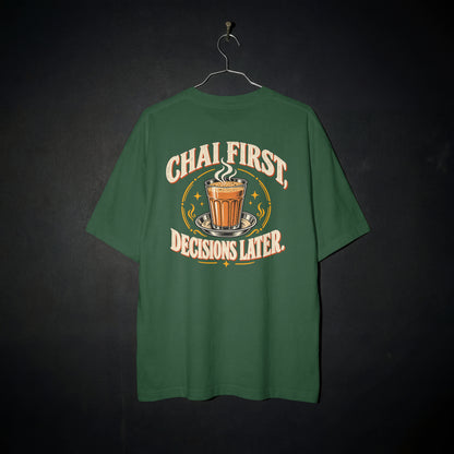 Bottle Green Chai First Decisions Later oversized T-shirt on a hanger against a dark backdrop, front view of the cutting chai graphic print