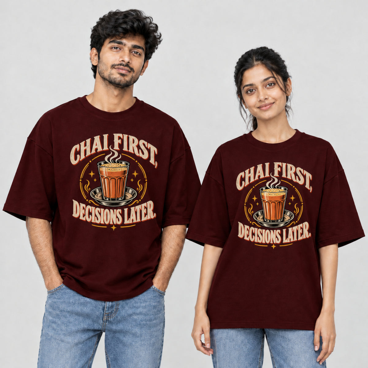 Maroon Chai First Decisions Later unisex oversized T-shirt worn by a man and a woman, front print with a cutting chai glass and retro cream lettering