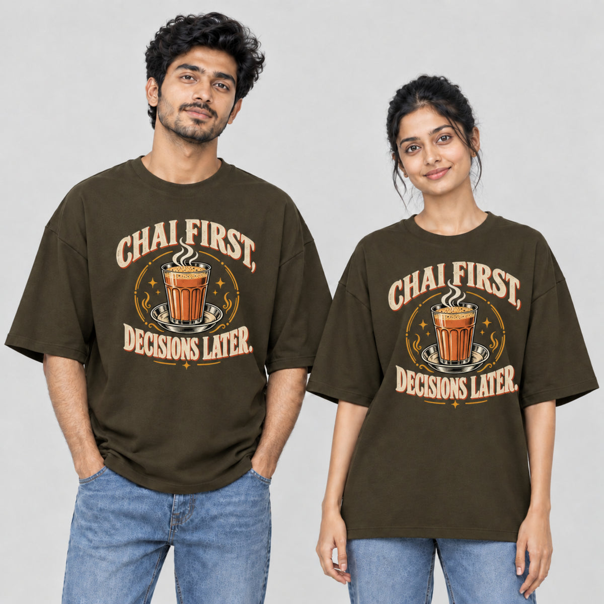 Olive Green Chai First Decisions Later unisex oversized T-shirt worn by a man and a woman, front print with a cutting chai glass and retro cream lettering