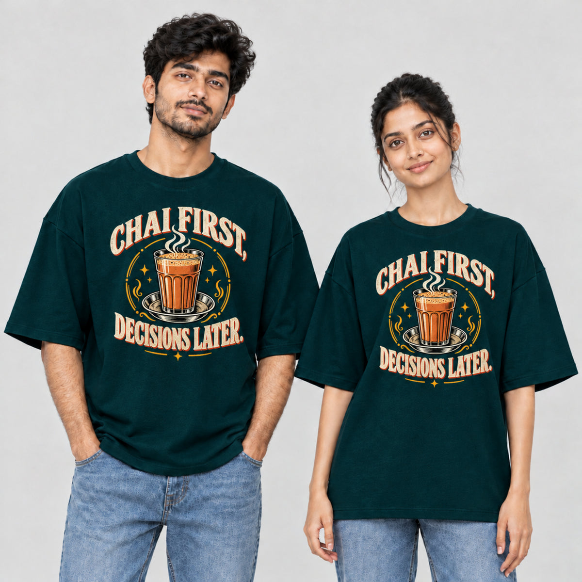Petrol Blue Chai First Decisions Later unisex oversized T-shirt worn by a man and a woman, front print with a cutting chai glass and retro cream lettering