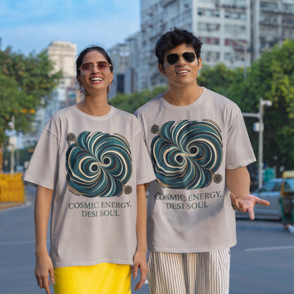 Two models wearing melange grey Nauma oversized t-shirts with a teal and gold colliding black holes print