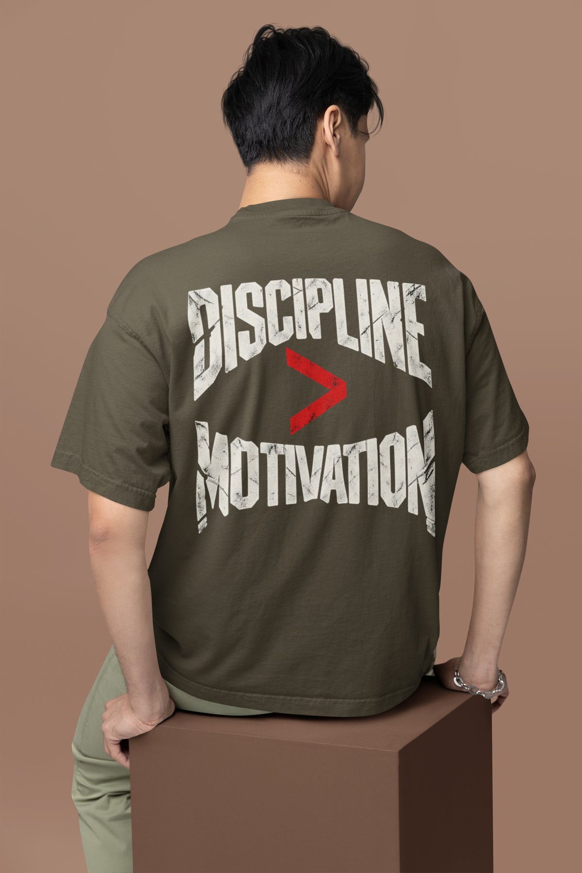 Olive Green Discipline Over Motivation back print unisex oversized t-shirt worn by a man, back view
