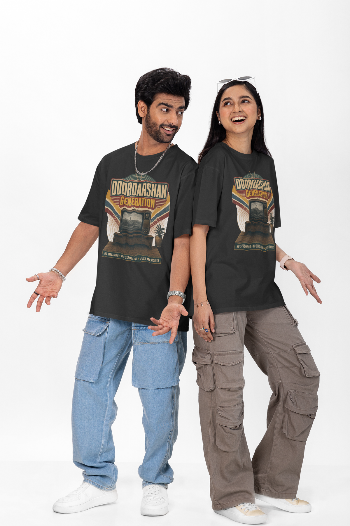 Man and woman wearing the Black Doordarshan Generation oversized t-shirt with baggy jeans on a plain backdrop