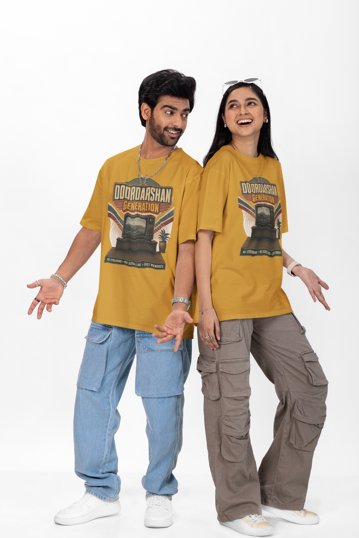 Man and woman wearing the Mustard Yellow Doordarshan Generation oversized t-shirt with baggy jeans on a plain backdrop