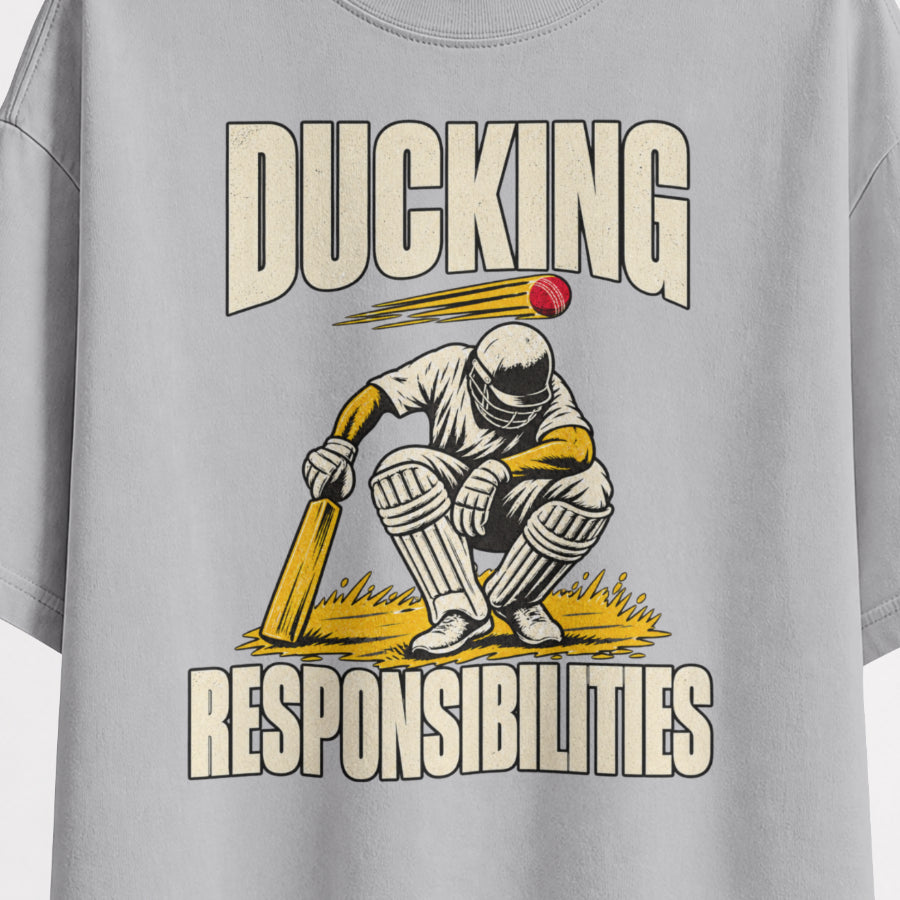 Melange Grey Ducking Responsibilities oversized T-shirt print close-up, vintage cricket batter ducking a red ball with bold outlined RESPONSIBILITIES lettering