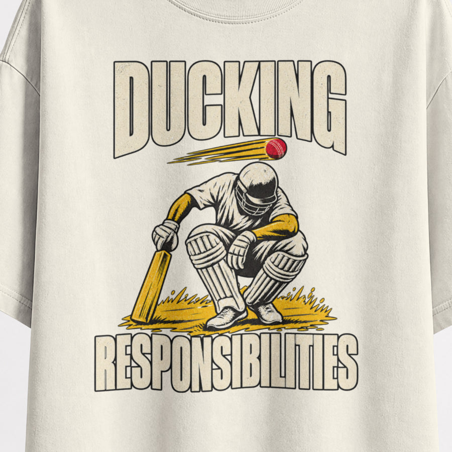 Off white Ducking Responsibilities oversized T-shirt print close-up, helmeted cricket batter crouching as a red ball flies past, cream and mustard print